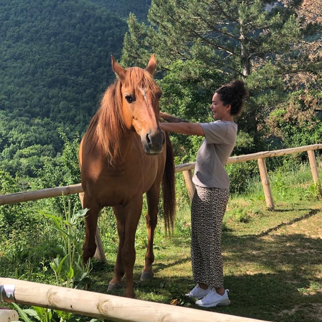 a woman petting a horse