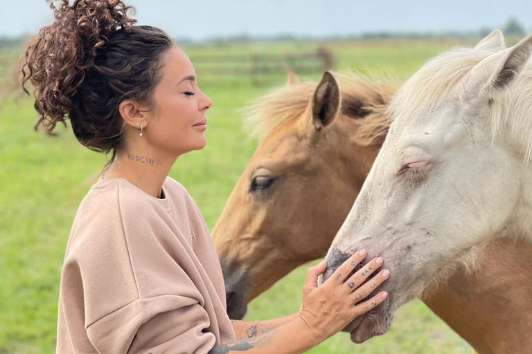 a woman petting a horse