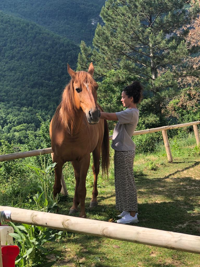 a woman standing next to a horse